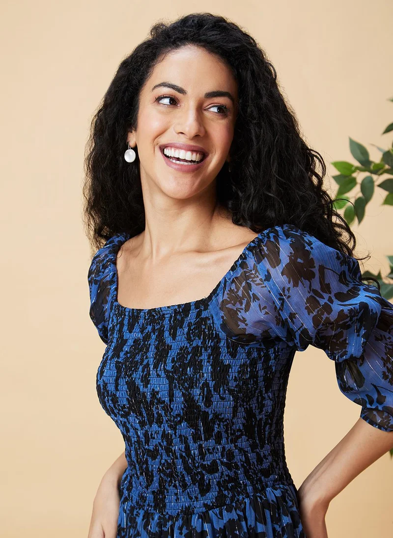 جلو باص فستان نسائي أزرق مطبوع بالزهور بياقة مربعة وأكمام منفوشة وخصر مزموم وطبقات وتنورة واسعة بطول ميدي